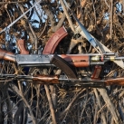Two rifles belonging to Nyangatom men hang on a brush fence. (Photo by Luke Glowacki)